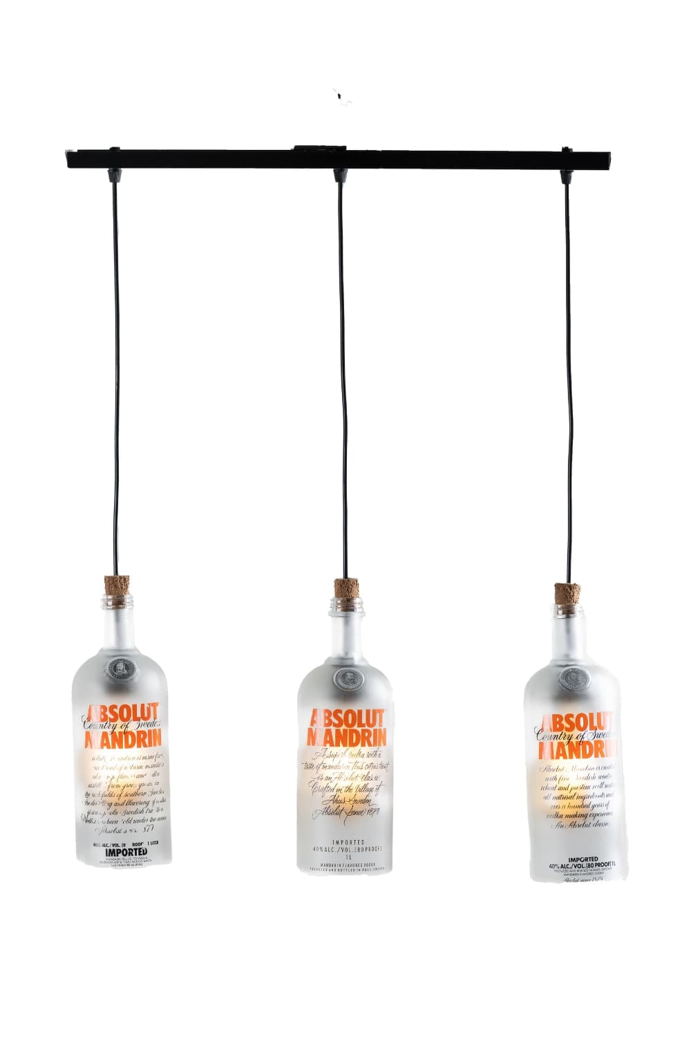 Three frosted glass bottle chandeliers with orange lettering hang from a black rail, lit from inside, on a white background