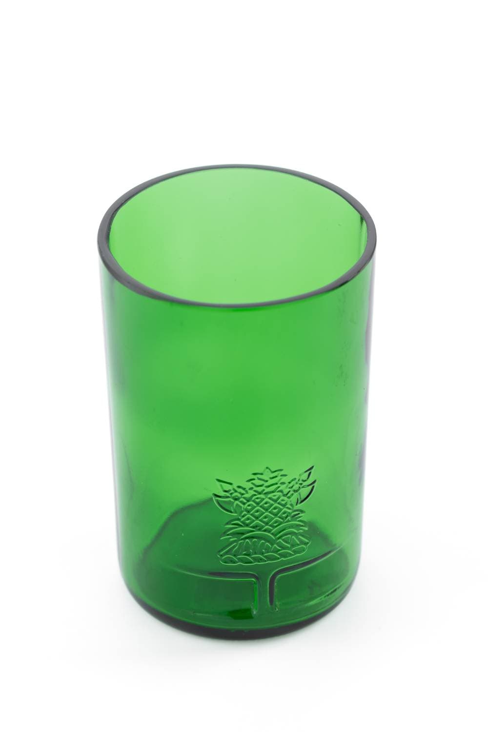 A green glass piece with an embossed pineapple motif near the base, seen from above on a white background